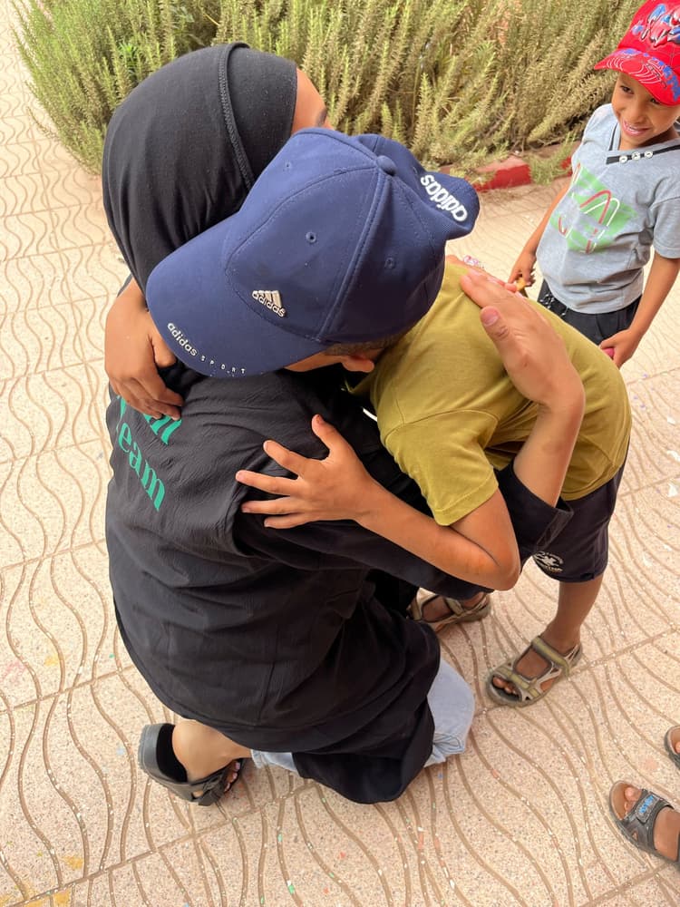 Photo d'un calin entre une bénévole et un orphelin